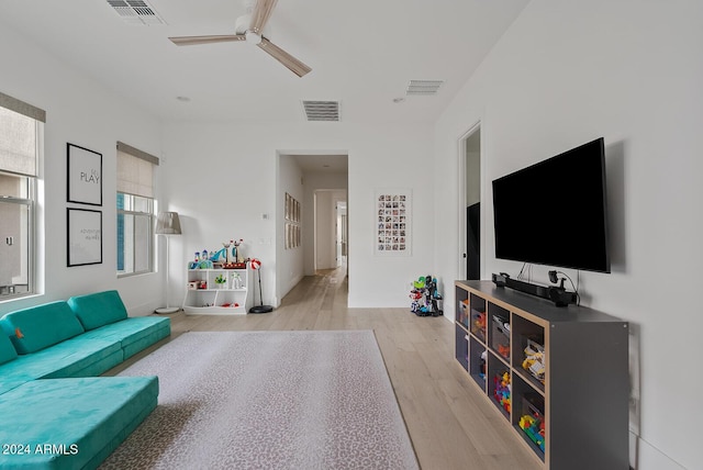 living room featuring ceiling fan and light wood-type flooring