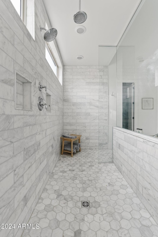 bathroom with tiled shower and a healthy amount of sunlight