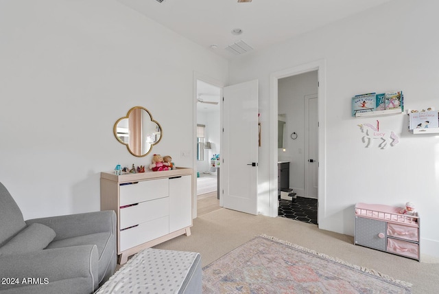 bedroom featuring ensuite bathroom and light colored carpet