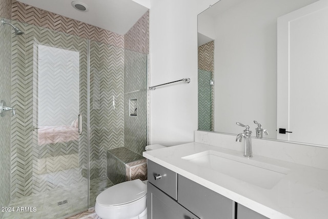 bathroom featuring vanity, toilet, and a tile shower