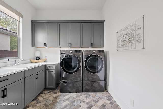 laundry room featuring cabinets, sink, and washing machine and dryer