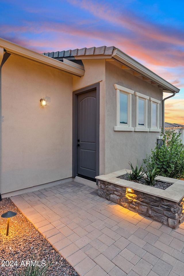 exterior entry at dusk with a patio