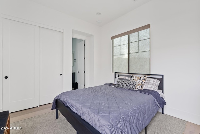 bedroom with light wood-type flooring and a closet