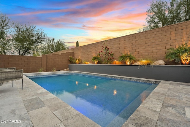 pool at dusk with a patio