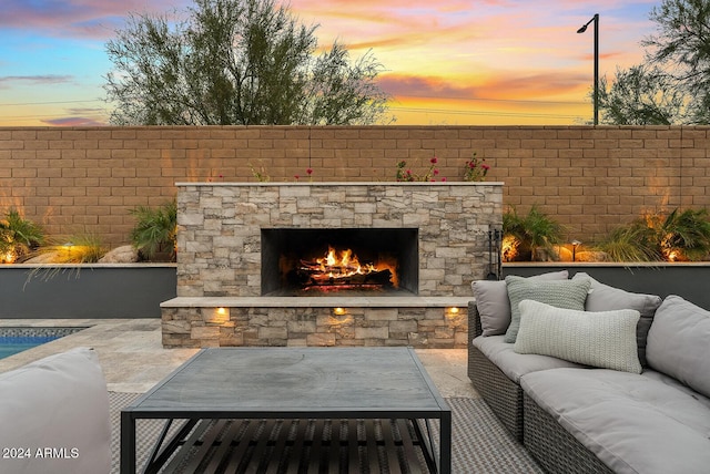 patio terrace at dusk featuring an outdoor living space with a fireplace