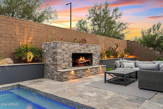 patio terrace at dusk with an outdoor living space with a fireplace