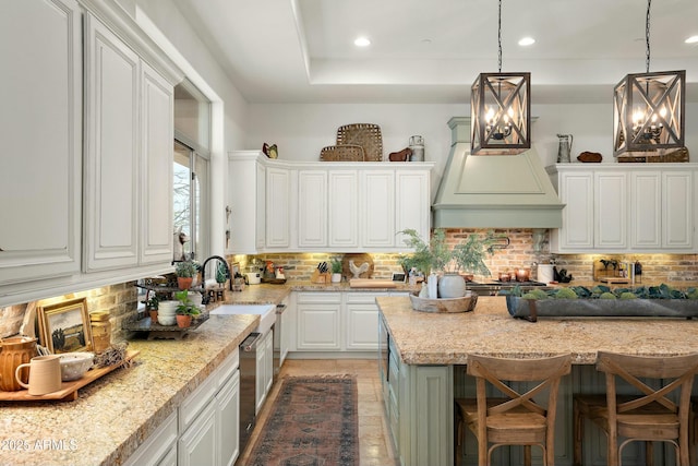 10799 E Florence Way, Scottsdale, AZ 85262 - kitchen featuring premium range hood, decorative backsplash, and white cabinetry