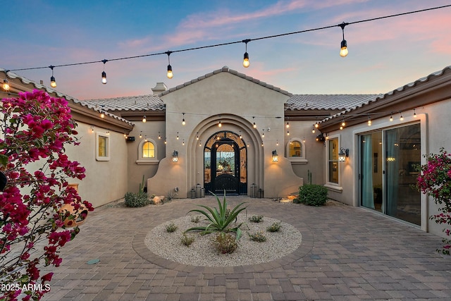 10799 E Florence Way, Scottsdale, AZ 85262 - back of house at dusk featuring a patio, stucco siding, and a tiled roof