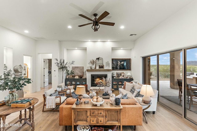 10799 E Florence Way, Scottsdale, AZ 85262 - living area featuring a glass covered fireplace, light wood-type flooring, recessed lighting, visible vents, and ceiling fan