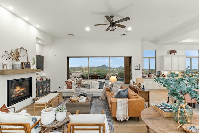 10799 E Florence Way, Scottsdale, AZ 85262 - living room featuring visible vents, a ceiling fan, a glass covered fireplace, and recessed lighting