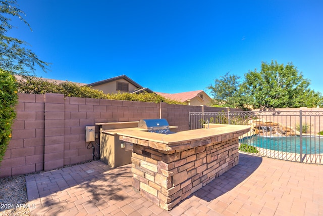 view of patio featuring a fenced in pool, a grill, and exterior kitchen