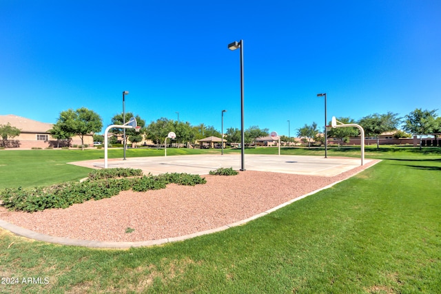 view of property's community featuring a lawn and basketball court