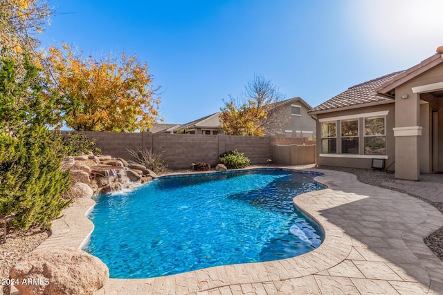 view of swimming pool featuring pool water feature and a patio