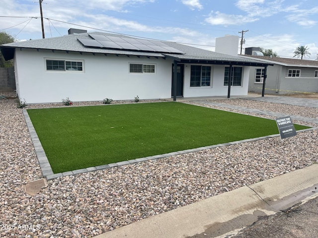 4531 N 12th Dr, Phoenix, AZ 85013 - rear view of property featuring a shingled roof, solar panels, stucco siding, and a lawn