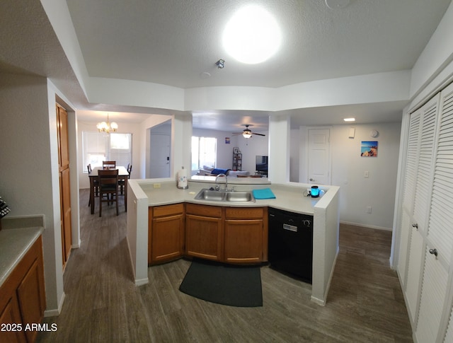 kitchen with ceiling fan with notable chandelier, black dishwasher, a kitchen island, and sink