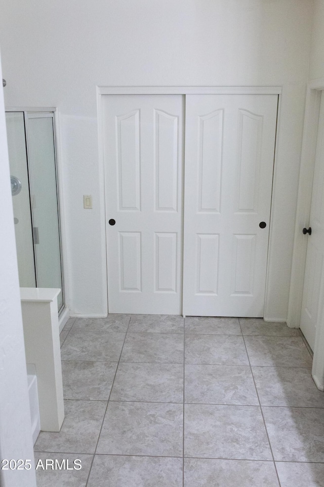 interior space featuring light tile patterned flooring and a closet