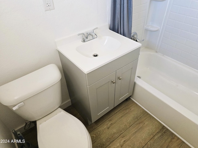 full bathroom with vanity, washtub / shower combination, toilet, and wood finished floors