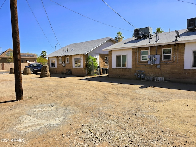 rear view of house featuring cooling unit and brick siding