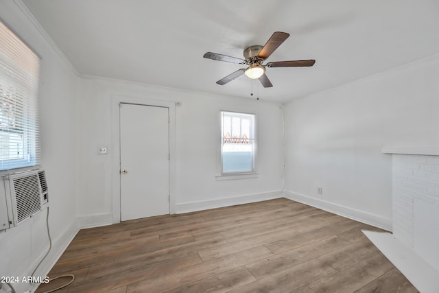 empty room with ceiling fan, baseboards, wood finished floors, and a fireplace