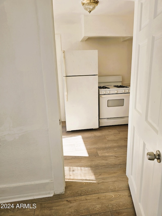 kitchen featuring white appliances and wood finished floors