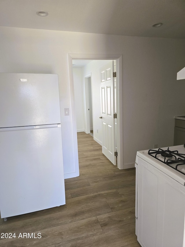 kitchen with white appliances, baseboards, and dark wood-style flooring