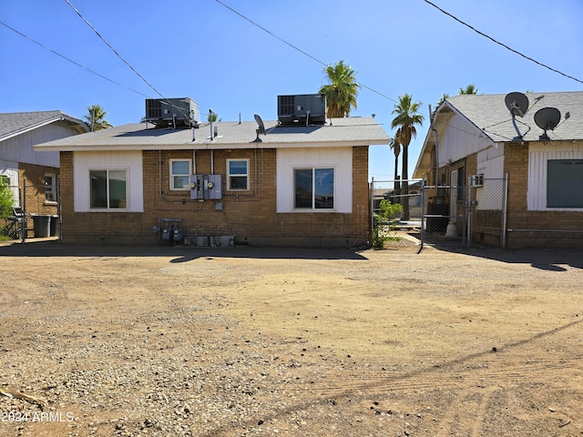 back of house featuring brick siding, cooling unit, and fence