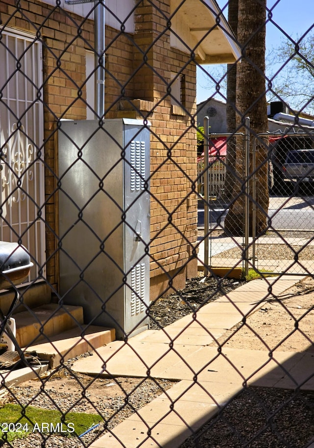 exterior details featuring brick siding and fence