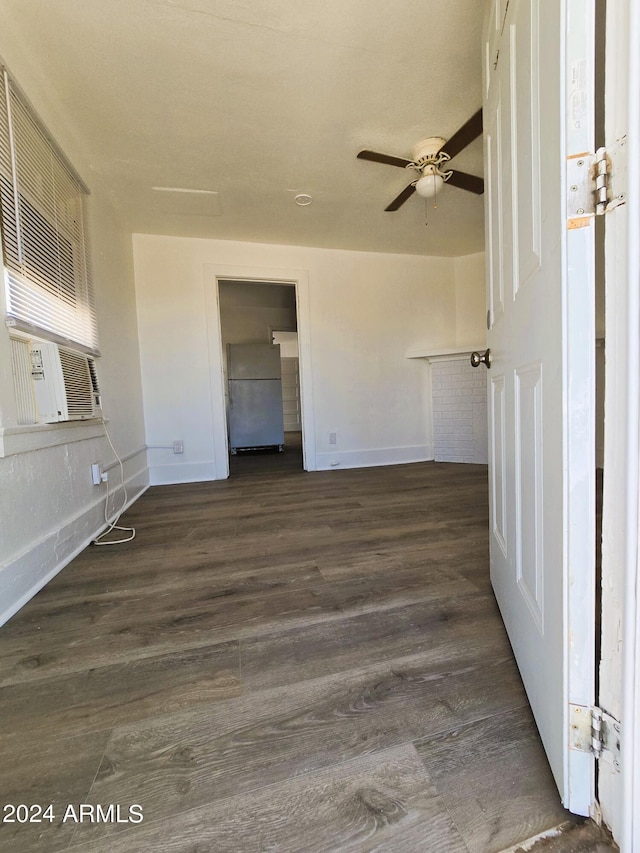 unfurnished room featuring dark wood finished floors, cooling unit, a ceiling fan, and baseboards