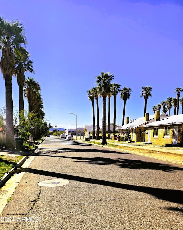 view of street featuring a residential view, curbs, street lighting, and sidewalks