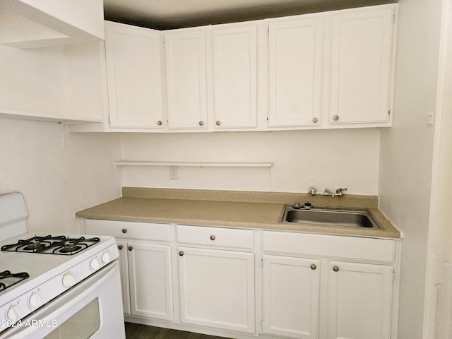 kitchen featuring a sink, white gas range, white cabinets, and light countertops