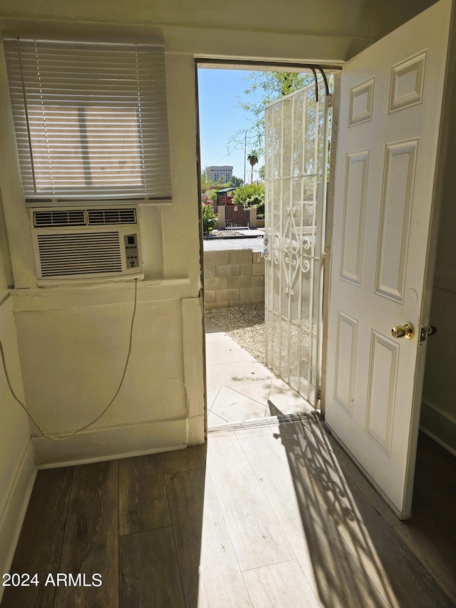 doorway to outside featuring cooling unit and wood finished floors