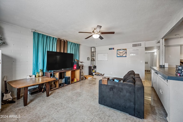 living room with ceiling fan and a textured ceiling