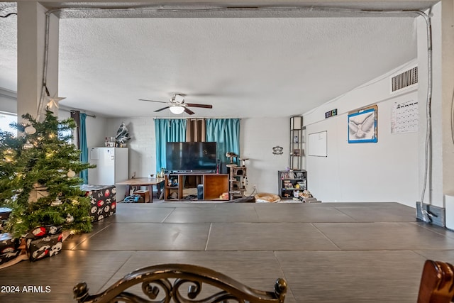 interior space with a textured ceiling and ceiling fan