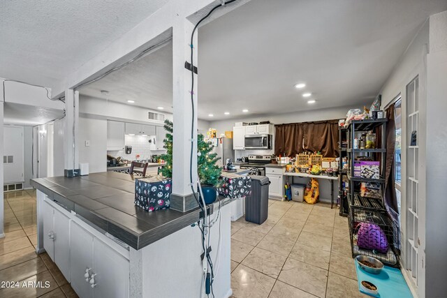 kitchen with backsplash, stainless steel appliances, white cabinetry, and dark brown cabinetry