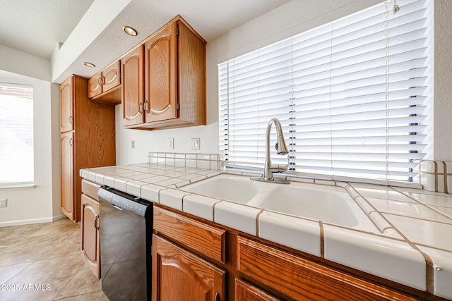 kitchen with tile countertops, light tile patterned flooring, a sink, dishwasher, and brown cabinets