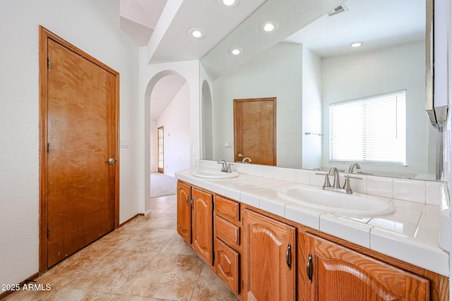 full bath featuring double vanity, visible vents, recessed lighting, and a sink