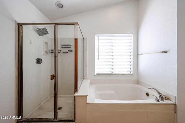 bathroom with a stall shower, a garden tub, and vaulted ceiling