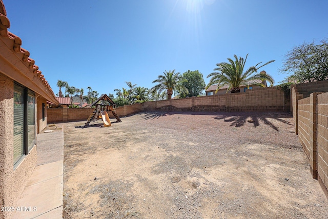 view of yard with a playground and a fenced backyard