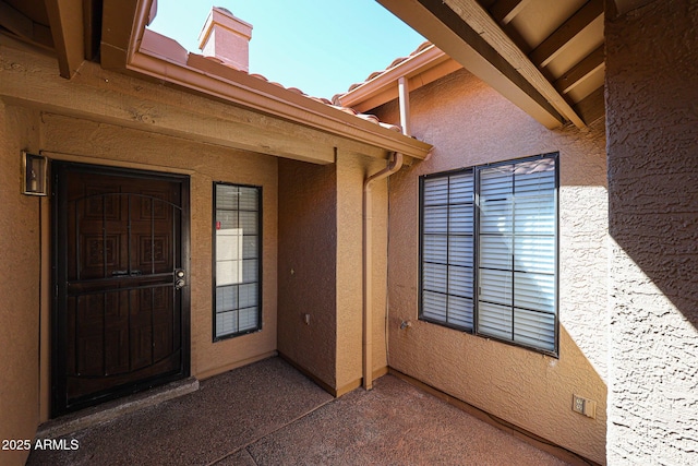 doorway to property featuring stucco siding