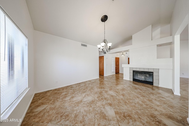 unfurnished living room with visible vents, baseboards, a fireplace, lofted ceiling, and a chandelier