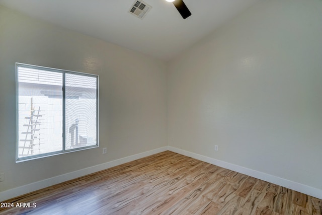 empty room with lofted ceiling, light hardwood / wood-style floors, and ceiling fan