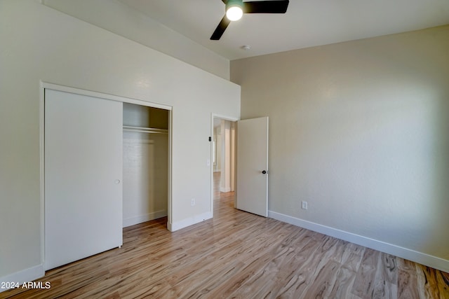 unfurnished bedroom featuring light wood-type flooring, ceiling fan, and a closet