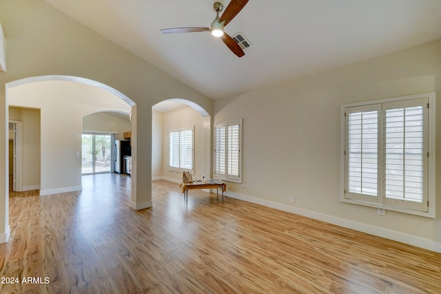 empty room featuring ceiling fan, light wood-type flooring, and vaulted ceiling