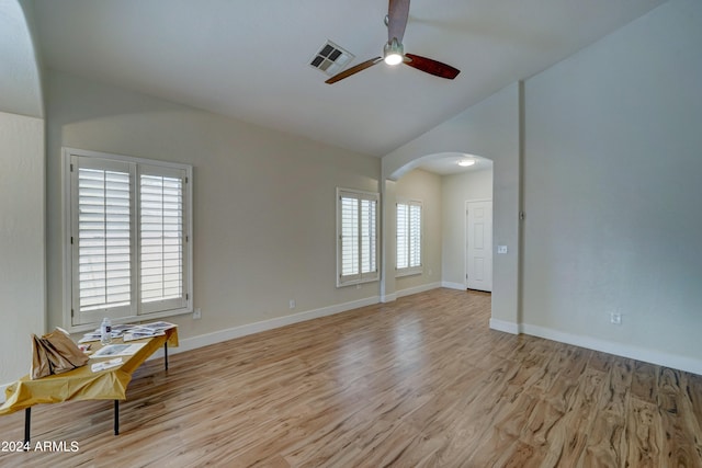 spare room featuring light wood-type flooring, vaulted ceiling, and ceiling fan