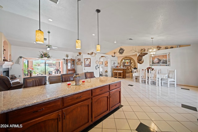 kitchen featuring light tile patterned flooring, a textured ceiling, lofted ceiling, and hanging light fixtures