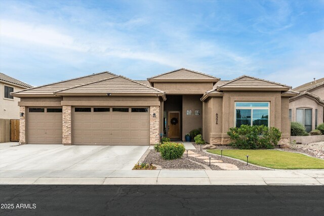 6326 W Misty Willow Ln, Glendale, AZ 85310 - prairie-style home with a garage, driveway, stucco siding, a tiled roof, and a front lawn