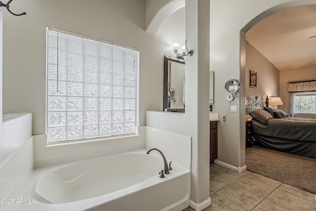 ensuite bathroom with vanity, tile patterned flooring, a garden tub, and ensuite bath
