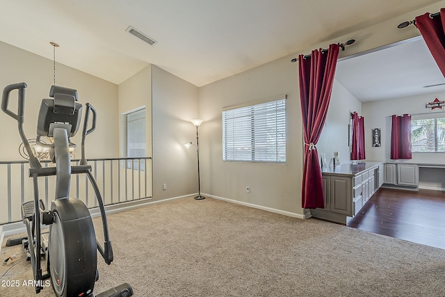 workout room featuring baseboards, visible vents, and dark colored carpet
