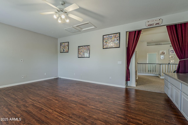 unfurnished living room with baseboards, ceiling fan, and dark wood-type flooring