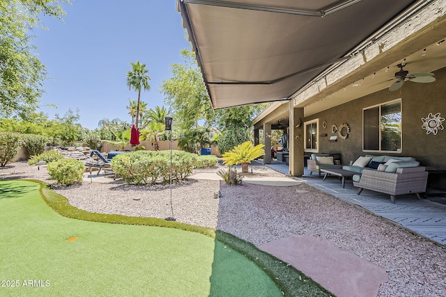 view of yard featuring fence, a ceiling fan, a patio, and outdoor lounge area